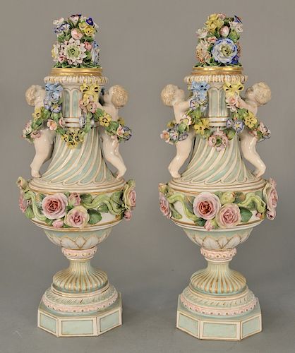 Pair of Meissen figural covered urns with floral tops, 
each urn mounted with putti and strings of flowers on floral bodies, set on ...