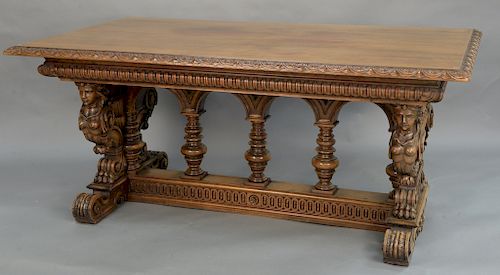Walnut writing table having carved edge supported by caryatids, on scroll foot (with glass top, sun faded). 
height 32 inches, top: ...