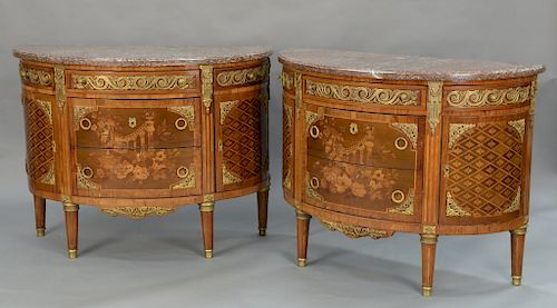 Pair of Louis XVI style demilune commodes with marble tops,  over cabinet of three center drawers, inlaid and gilt bronze mounted fl...