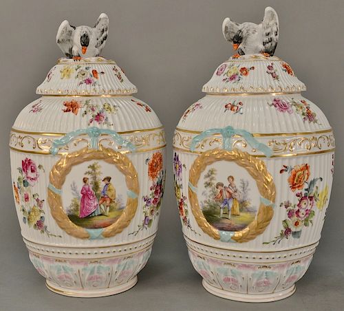 Near pair of porcelain covered urns,  having eagle finial covers on bulbous form body with gilt wreath on each side and hand painted...