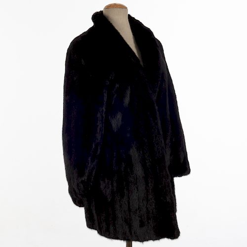 Abrigo. Siglo XX. Elaborado en piel de mink color negro. Talla aproximada mediana. Incluye guarda polvo.