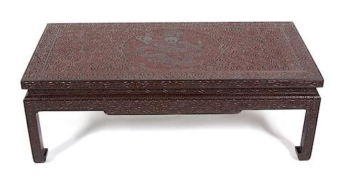 A Chinese Carved Black and Red Lacquer Low Coffee Table Height 16 x width 46 3/4 x depth 23 1/4 inches.