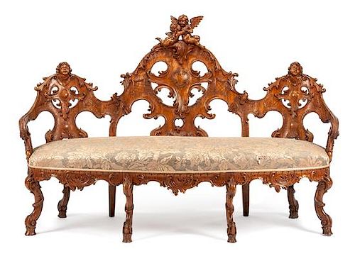 A Black Forest Carved Walnut Settee Height 47 1/2 x width 71 x depth 26 inches.