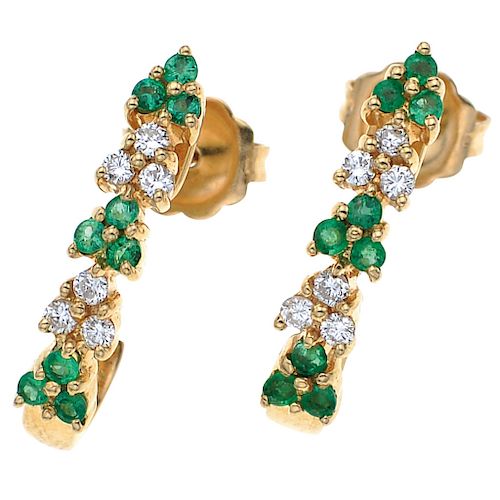 An emerald and diamond 14K yellow gold pair of earrings.