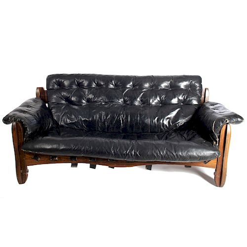Sofá de 3 plazas. Siglo XX. Elaborado en madera tropical. Diseño Don S. Shoemaker. Con respaldo y asiento capitonados en piel negra.