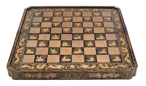 A Chinese Export Gilt Decorated Black Lacquer Folding Game Board Height 3 1/2 x width 19 1/2 x depth 10 inches.