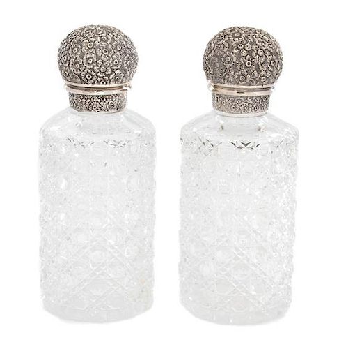 A Pair of English Cut Crystal and Silver Repousse Top Scent Bottles Height 7 1/2 x diameter 3 inches.