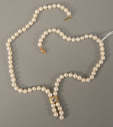 Pearl necklace with 14 karat clasp and 14 karat pendant set with light blue stone.