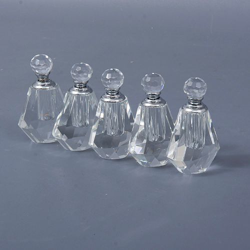 Lote de 5 perfumeros. Siglo XX. Elaborados en cristal. Decoración facetada geométrica. Cuentan con estuche.