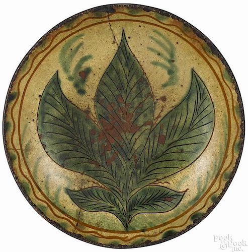 Southeastern Pennsylvania sgrafitto redware dish, early 19th c., with a central green tobacco leaf