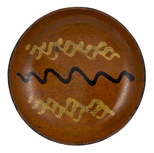 Pennsylvania redware pie plate, 19th c., with yellow and brown slip wavy line decoration