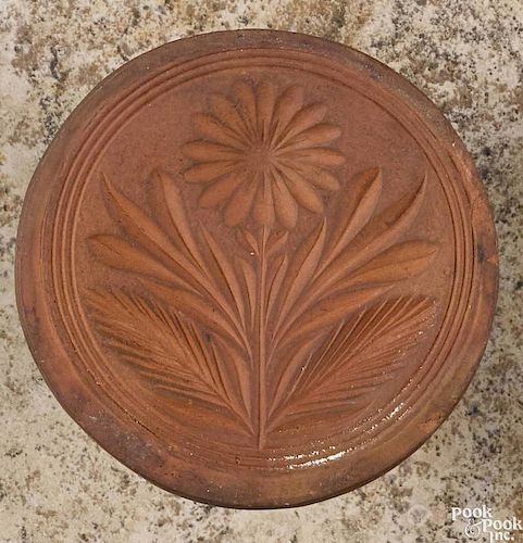 Pennsylvania redware butter print, 19th c., with floral decoration, 4'' dia.