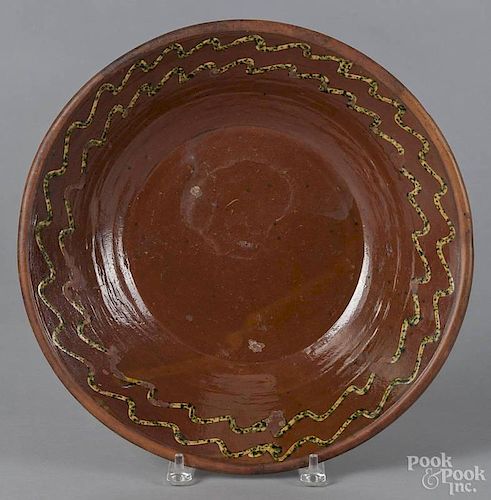 Large redware mixing bowl, 19th c., slip decorated with green-speckled yellow wavy lines, 2 3/4'' h.