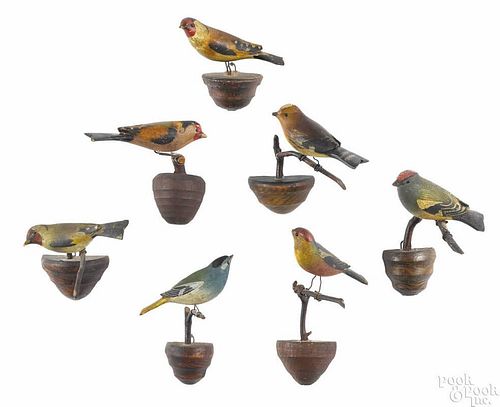 Seven carved and painted songbirds, early 20th c., on twig perches, approx. 5'' h.