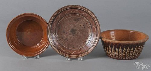 Three pieces of redware, to include a bowl stamped AG Smith, Greenwood PA, 2 1/4'' h., 8'' dia.