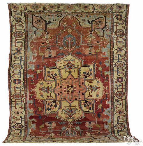Serapi carpet, ca. 1900, with a central ivory medallion on a brick red field with ivory borders