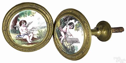 Pair of Continental brass tie backs, 19th c., with enamel scenes of putti, 3'' l., 2'' dia.