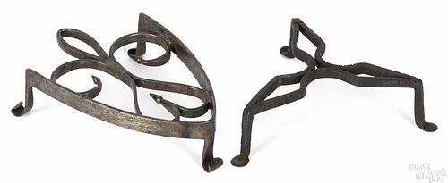Two wrought iron trivets, 19th c., one with a scrolled heart with tulip bud terminals