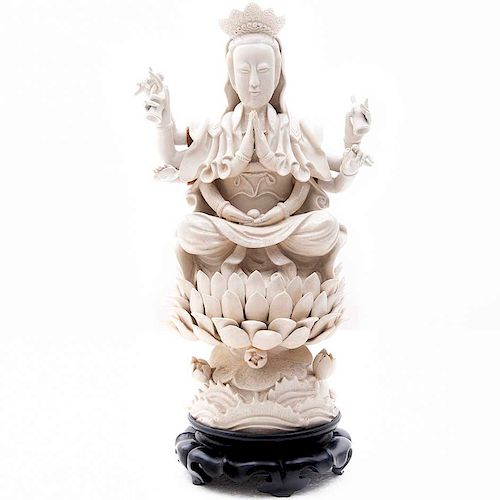 Avalokitesvara sobre flor de loto. China, siglo XX. Elaborada en cerámica blanca vidriada. Con base de madera. Brazos moviles.