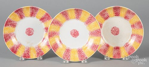 Three red and yellow rainbow spatter saucers