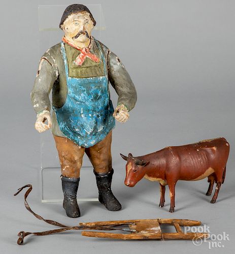 Carved and painted figures of a man and cow