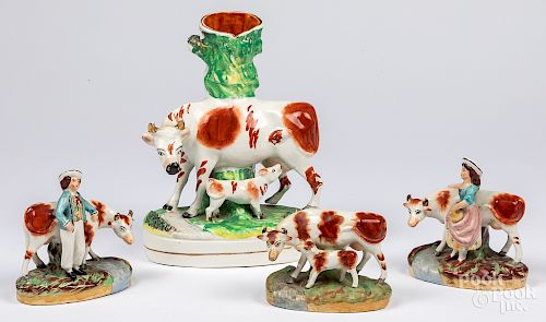 Four Staffordshire cow figural groups