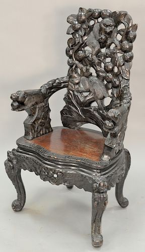 Carved Oriental armchair with carved monkeys and fruit. ht. 48 1/2 in.