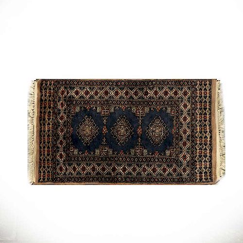 Tapete. Pakistán, siglo XX. Estilo Bokahara. Elaborado en fibras de acrílico, lana y algodón. Decorado con motivos geométricos.