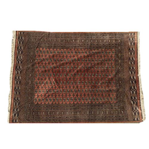 Tapete. Pakistán, siglo XX. Estilo Bokahara. Anudado a mano en fibras de lana y algodón. Decorado con motivos geométricos.