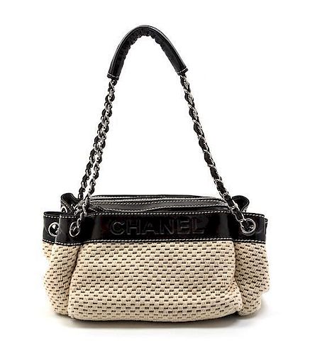 * A Chanel Ivory Woven and Black Leather Trim Bag, 11 x 6 x 5 inches.