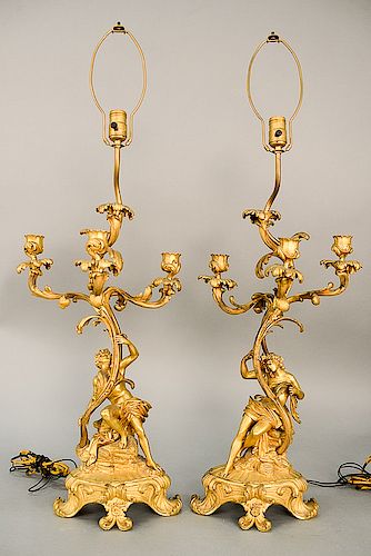 Pair of figural gilt bronze candelabras, each having scrolling foliate four arms figural partially clad male on one and female on th...