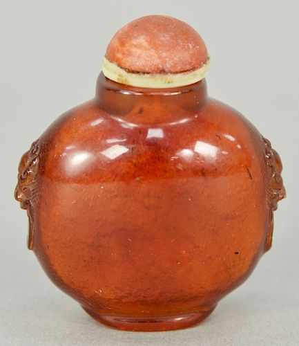 Amber snuff bottle having lion mask fixed rings.  ht. 1 3/4 in.