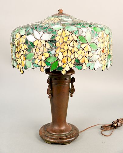 Handel table lamp having leaded stained glass shade with yellow floral pattern, on bronze urn form handled base, marked: Handel.  ...