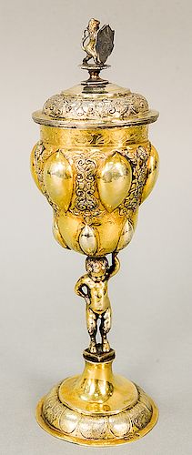 Russian silver gilt chalice having cover with finial, lobbed body held by putti on round base with overall gilt decoration, marked:...
