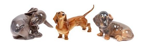 * A Group of Three Dachshund Porcelain Figures Width of widest 5 1/8 inches.