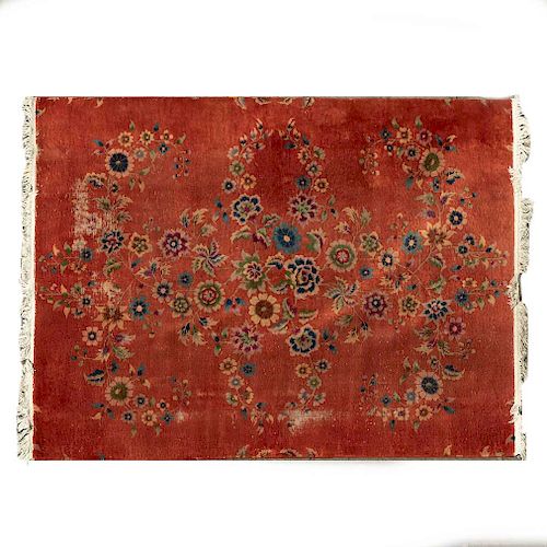 Tapete. Siglo XX. Elaborado en fibras de lana y algodón. Decorado con motivos florales sobre fondo rojo.
