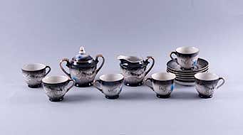 Servicio abierto de té Japón,S. XX.Elaborada en semi porcelana tipo tsatsuma, color negro.Decorados con dragones en alto relieve.Pzs:14