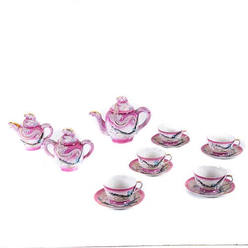 Servicio de té. Japón, siglo XX. Elaborado en porcelana tipo tsatuma color rosa. tetera, cremera, azucarera. Piezas: 18