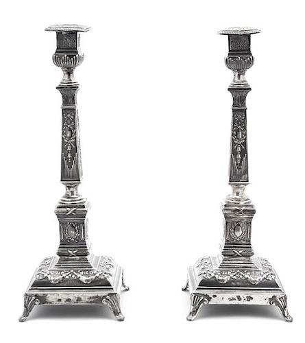 A Pair of Russian Silver Candlesticks, Russia, Late 19th Century, with faceted stem, stepped base, molded with classical motifs