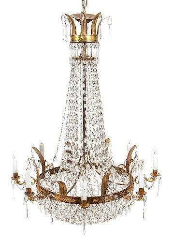 A Regency Style Gilt Metal and Glass Swag Tiered Chandelier Height 48 x diameter 32 inches.
