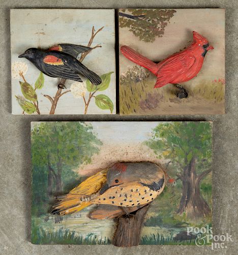 Three carved and painted bird plaques