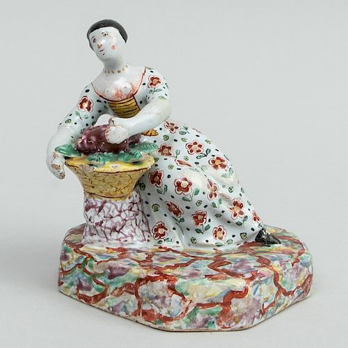 Dutch Polychrome Delft Figure of a Seated Woman with Basket of Grapes