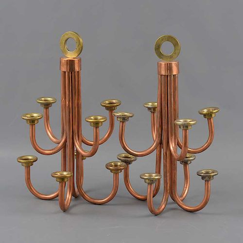 Par de candelabros. Siglo XX. Elaborados en cobre. Para 8 luces. Con brazos curvos y arandelas circulares.