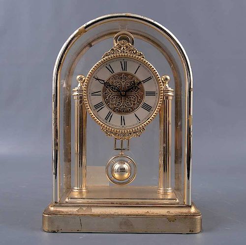Reloj de escritorio. Japón. Siglo XX. De la firma Seiko. Mecanismo de cuarzo y péndulo. Elaborado en metal dorado.