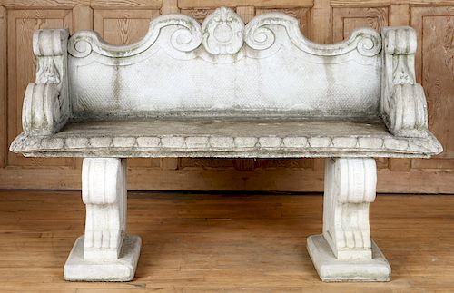 A CAST STONE GARDEN BENCH RAISED ON TWO SUPPORTS