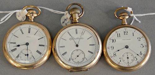 Three open face pocket watches, gold filled faces marked Waltham, Omega, and Elgin.