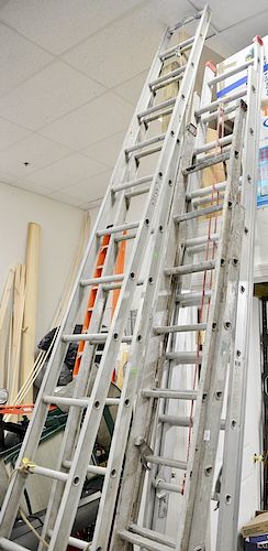 Group of three aluminum extension ladders.