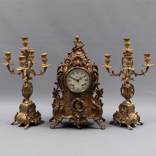 Guarnición. Francia. Siglo XX. Elaborada en bronce. Consta de: Reloj de mesa y par de candelabros.