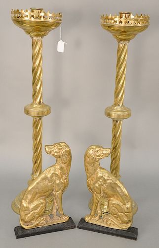 Four piece lot to include pair of brass dog door stops with iron bases (ht. 12 1/2 in.) and a pair of large candle holders (ht. 30 1...