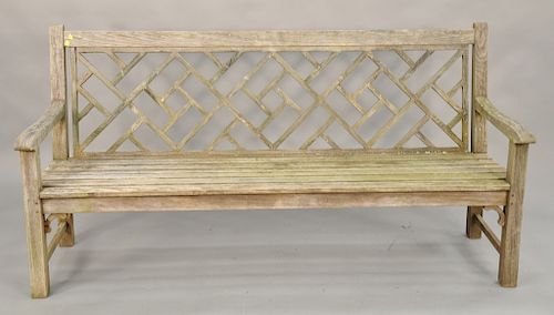 Teak outdoor bench with lattice back. ht. 38 in., lg. 74 1/2 in. Provenance: From the Estate of Deborah G. Black of Greenwich, Conne...